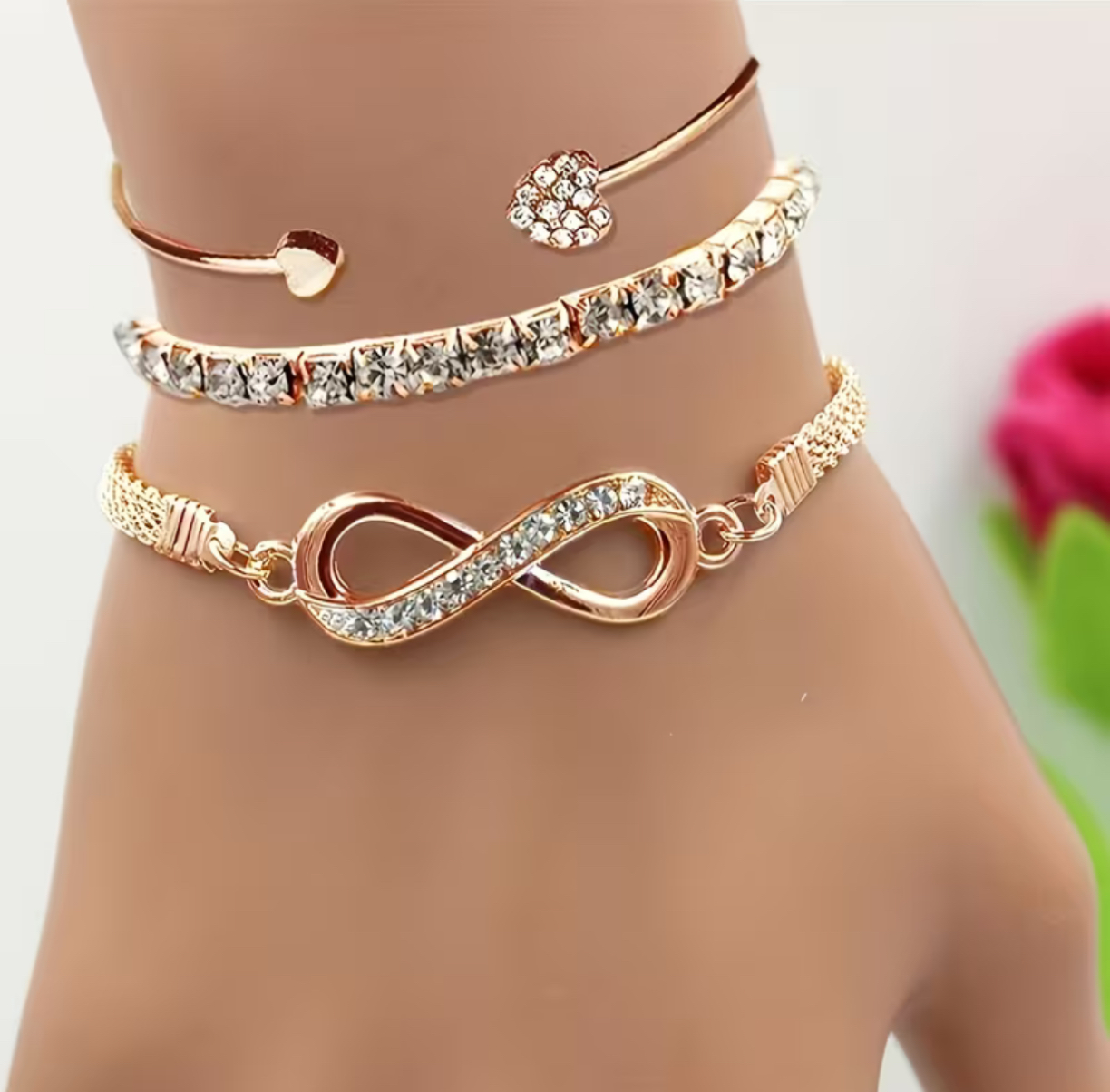 A Set of Three Women'S Bracelets And Bangles Featuring Wireless Symbols And Heart Designs Adorned with Rhinestones.